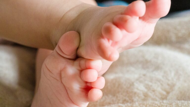 persons feet on white textile