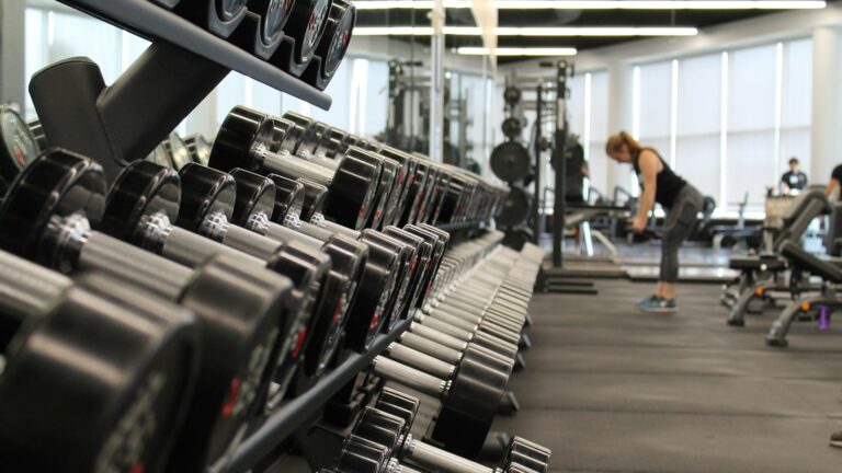 woman standing surrounded by exercise equipment