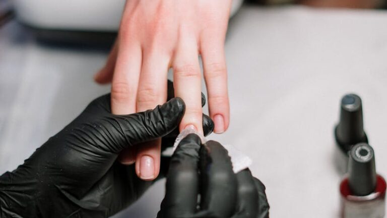 Close-up of a professional manicure with gel polish and black gloves in a salon.