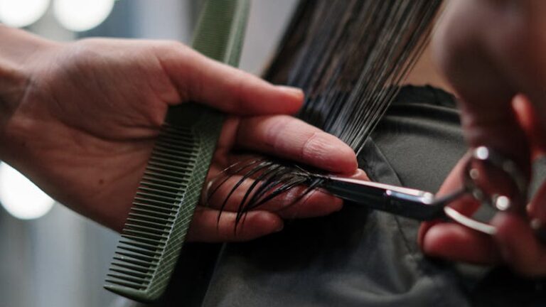 Close-up of hairstylist cutting wet hair in a salon.