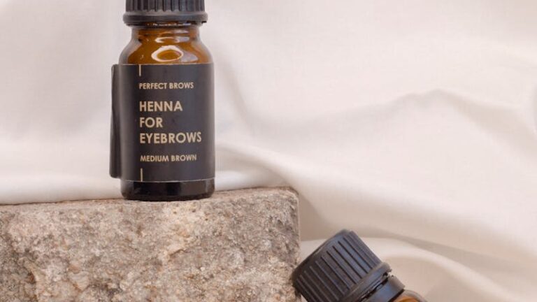 Two bottles of henna for eyebrows displayed on a textured stone surface.
